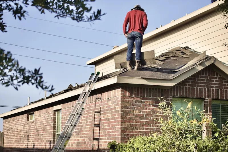 Professional roofer working on a residential roof in Hills Grove